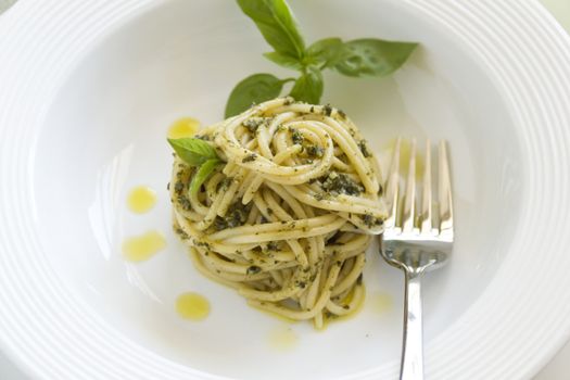 Delicious spaghetti with pesto with basil leaves ready to serve.