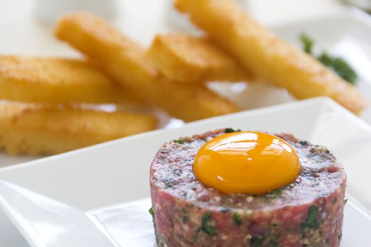 Delicious steak tartare with raw egg and fried bread strips ready to serve.