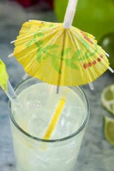 Delicious quenching lemon drink with ice and a cocktail umbrella.