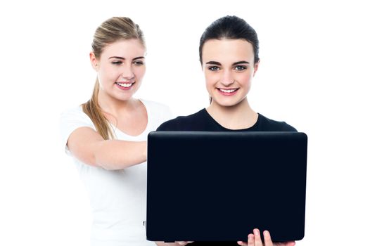 Smiling teen girls watching funny videos on laptop