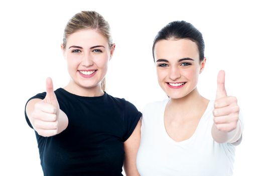 Two beautiful friends showing thumbs up with joy