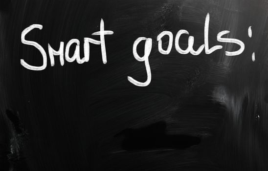 "Smart goals" handwritten with white chalk on a blackboard.