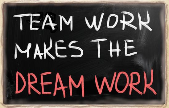 "Teamwork" handwritten with white chalk on a blackboard.
