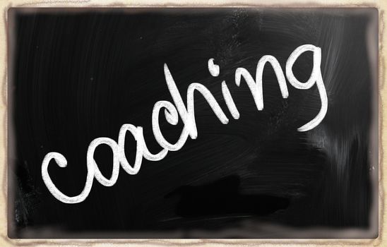 "Coaching" handwritten with chalk on a blackboard.