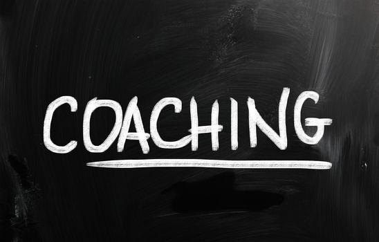 "Coaching" handwritten with chalk on a blackboard.
