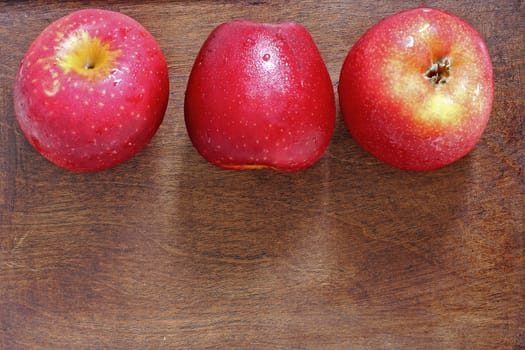 Three apples on the wood