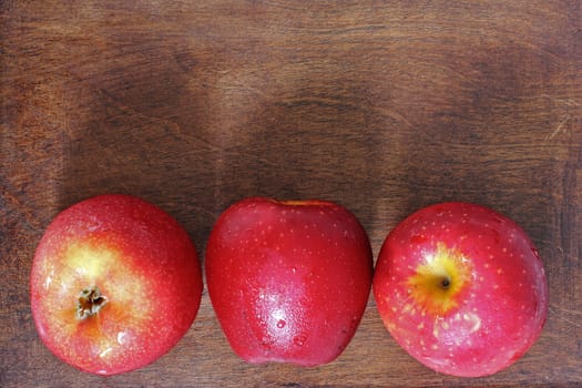 Three apples on the wood