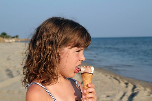 little girl eat ice cream on beach portrait