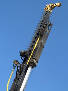 Pile-driver in action against the blue sky.