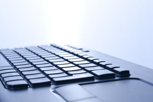 close up of a computer keyboard with blue light
