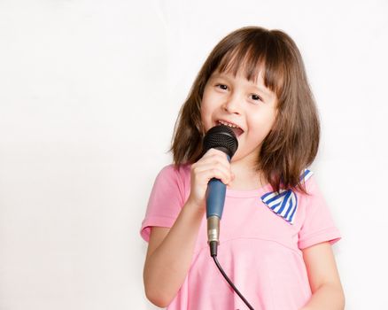 Asian child singing into a microphone