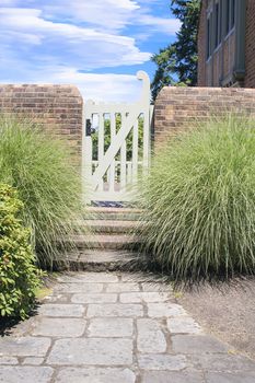 Natural Stone Path to Backyard Garden Gate with Brick Wall