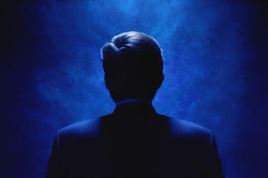 Silhouette of man bathed in blue light.