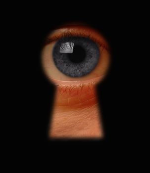 Eye peeking through a keyhole