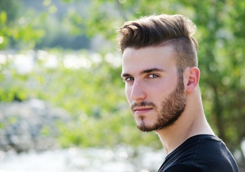 Portrait of attractive young man outdoors, looking in camera