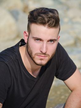 Portrait of attractive young man with black t-shirt, looking in camera