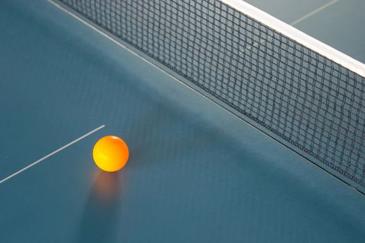 Orange table tennis ball on blue table