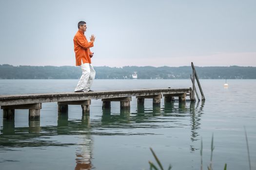 A man doing Qi-Gong in the early morning at the lake Starnberg