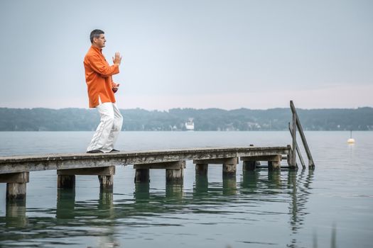 A man doing Qi-Gong in the early morning at the lake Starnberg
