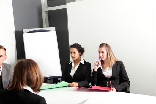 The businesspeople are discussing a project in conference room