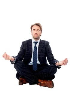 Handsome businessman meditating in lotus posture