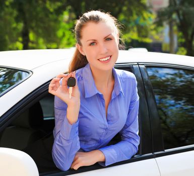 The happy girl showing the key of her new car