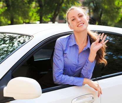 The happy girl showing the key of her new car