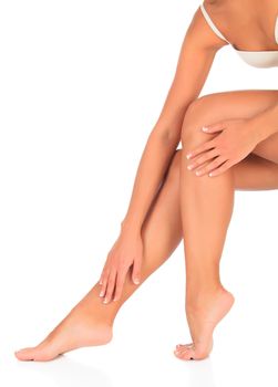 Woman touches her leg by hand, white background, copyspace