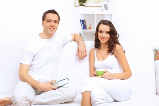 Young happy couple at hone together sitting and talking