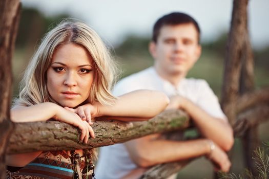 Young couple at sunset near a wooden fence
