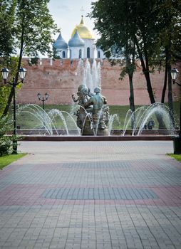 A fountain located in Veliky Novgorod, Russia, with church towers in the background