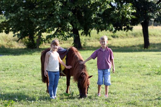 little girl and boy with pony horse