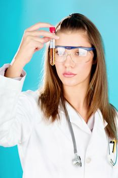 Young woman looking at the chemical tube, focus on tube