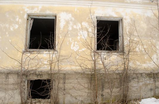 abandoned old masonry brick house wall and broken windows.