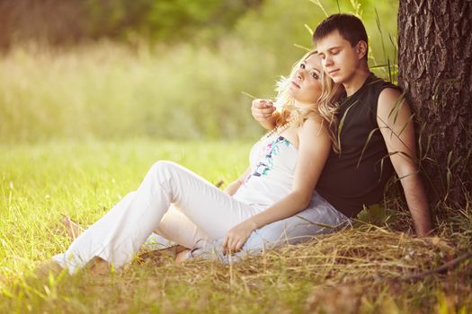 Young guy with a girl under the tree.