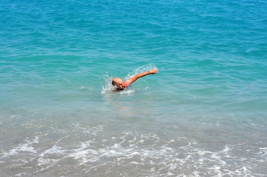 young man swimming in the mediterranean sea blue water