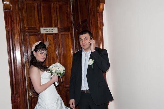 Bride and groom standing in front of the door