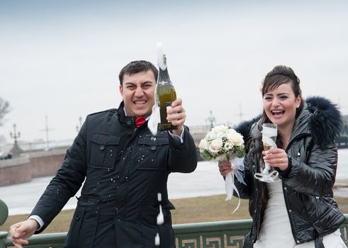 bride and groom drinking champagne in the street