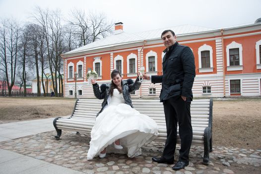 groom holds his bride in his arms and kisses