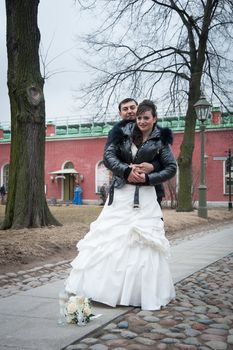 groom holds his bride in his arms and kisses