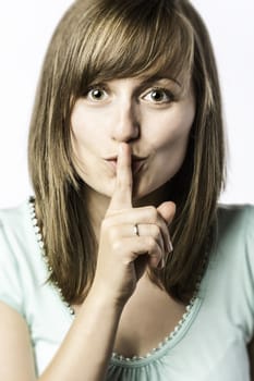 Young woman with finger on her mouth to indicate that you should be quiet