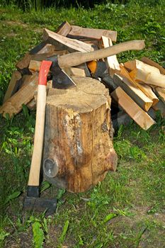 Axe splitting hammer and cut fire wood on a green grass