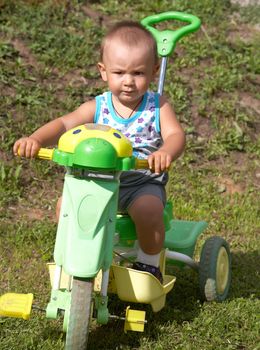 The little boy on a toy motorcycle in the afternoon