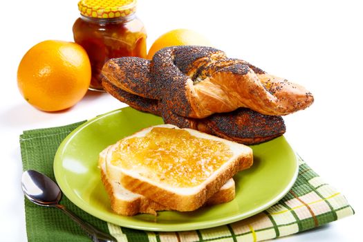 Still-life with bread rolls and jam on a white background