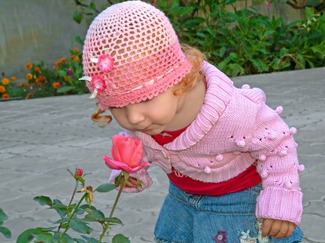 Little glamor girl with red hair, smell the blossoming roses