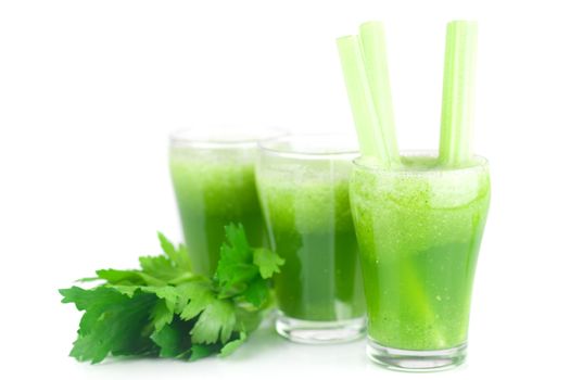 celery and three glasses with celery juice isolated on white