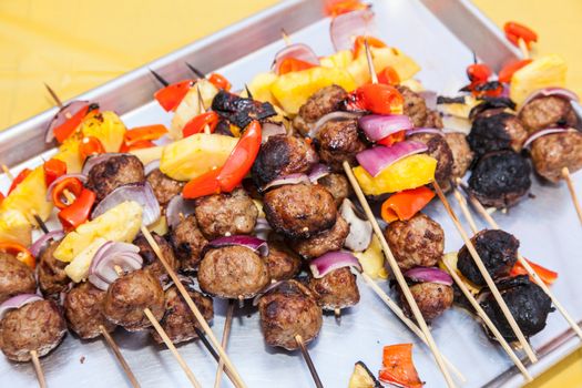 Delicious meatballs and pieces of pineapple, peppers and onion on skewers.