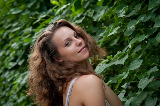 fashion model on a background of foliage in the summer in the heat