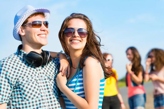 young couple standing on the road, having fun with friends