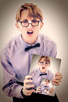 Adorable geeky teen boy holding electric notepad with photo of self.